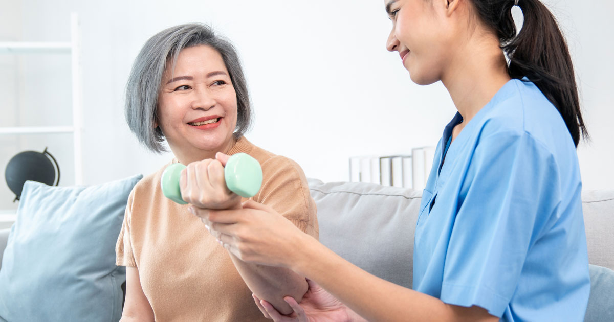 Caregiver Helping Senior Woman Exercise