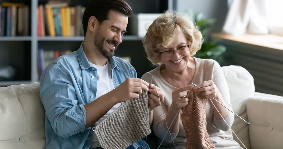 Elderly Mother Knitting With Son