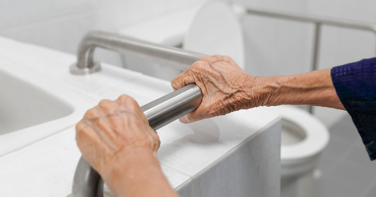 Elderly Woman Holding Bathroom Handrail