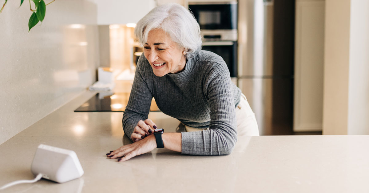 Elderly Woman Using a Smart Device in the Kitchen